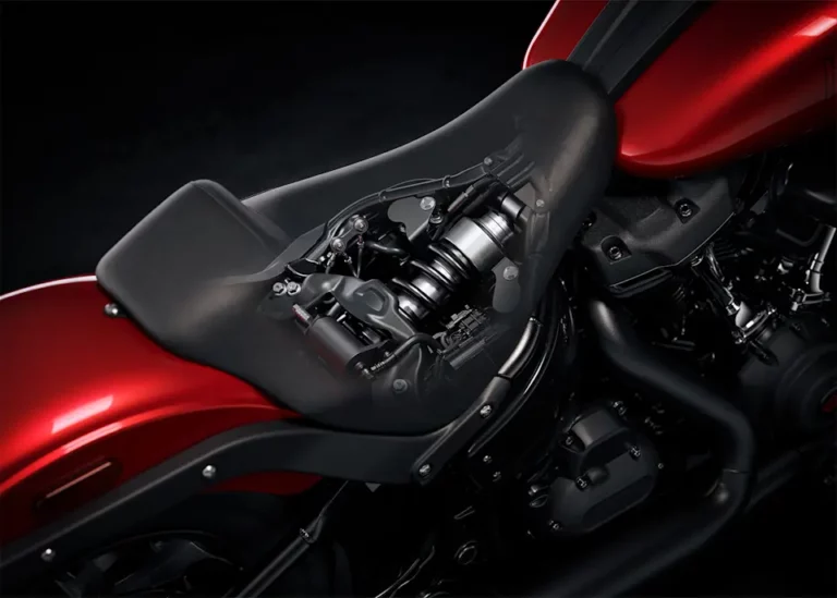 Das Bild zeigt eine Detailansicht des Motors einer Harley-Davidson Low Rider S, bei der der Sitz transparent dargestellt ist, um die technischen Komponenten darunter zu sehen.