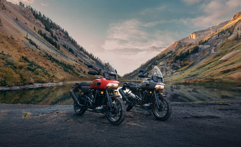 Die neuen Harley-Davidson 2026 Adventure Touring Modelle zusammen aufgestellt in einer Kulisse Bergen und vor einem See