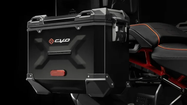 Die Abbildung zeigt eine schwarze Motorradbox mit dem Logo von Harley-Davidson, angebracht an einem Motorradsitz.