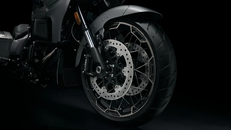 Nahaufnahme des Vorderreifens und der Bremsscheibe eines Harley-Davidson Motorrads vor schwarzem Hintergrund.