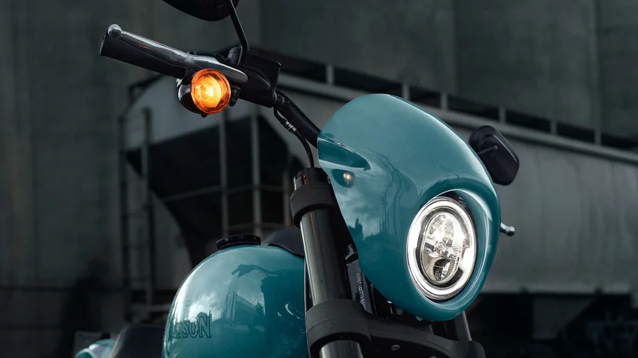 Nahaufnahme eines Harley-Davidson Motorrads mit einem blauen Scheinwerfer und einem orangefarbenen Blinklicht.