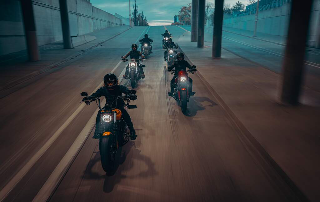 mehrere Harley-Davidson Cruiser Modelle fahren auf einer Straße